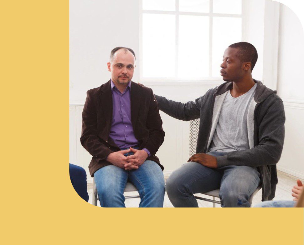 Two men sitting in a room talking to each other.