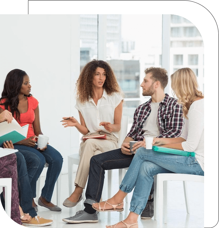 A group of people sitting around each other.